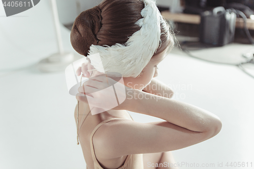 Image of Beautiful little ballerina wearing a white swan bandage on her head