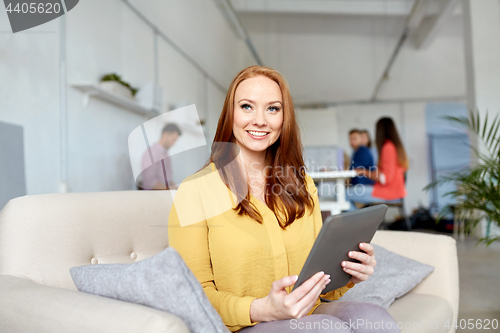 Image of redhead woman with tablet pc working at office