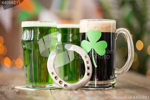 Image of shamrock on glass of beer and horseshoe on table