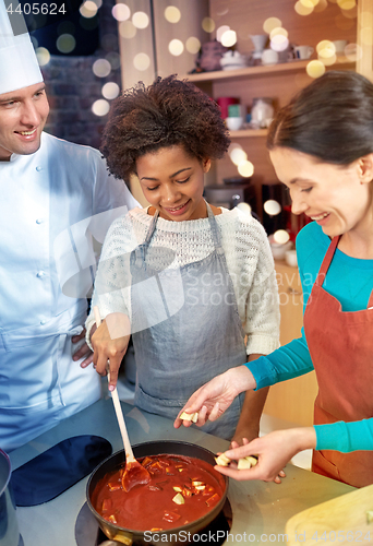 Image of happy women and chef cook cooking in kitchen