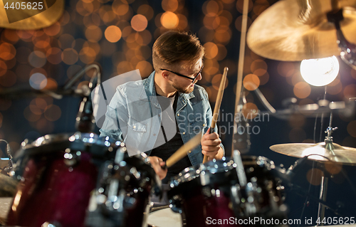 Image of male musician playing drums and cymbals at concert