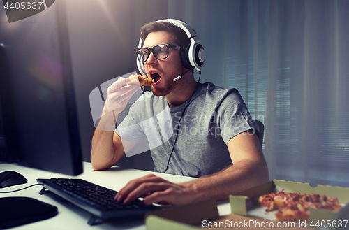 Image of man in headset playing computer video game at home