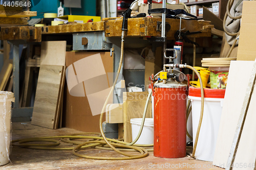 Image of glue gun with pump or compressor at workshop