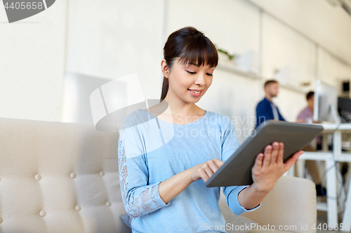 Image of happy asian woman with tablet pc working at office