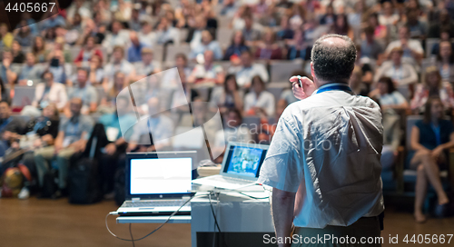 Image of Public speaker giving talk at Business Event.