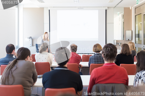 Image of Woman giving presentation in lecture hall at university.