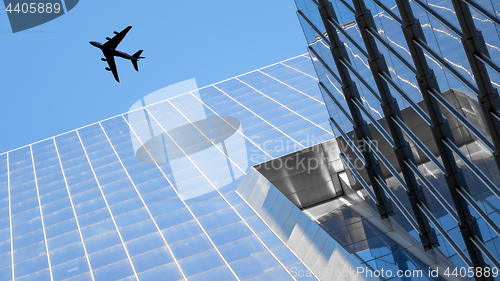 Image of a plane flying over modern buildings of New York City