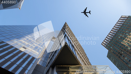 Image of a plane flying over modern buildings of New York City