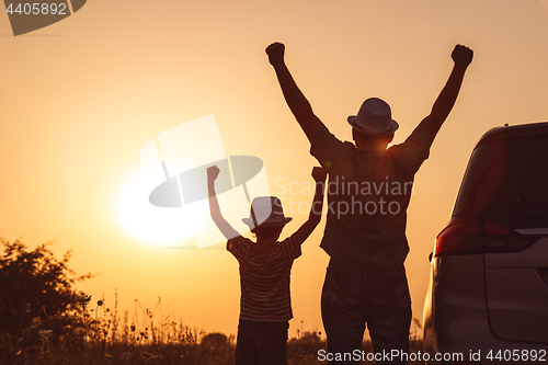 Image of Father and son playing in the park at the sunset time.