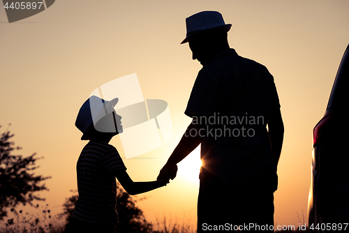 Image of Father and son playing in the park at the sunset time.