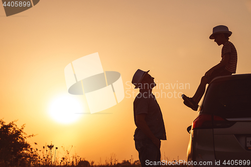 Image of Father and son playing in the park at the sunset time.