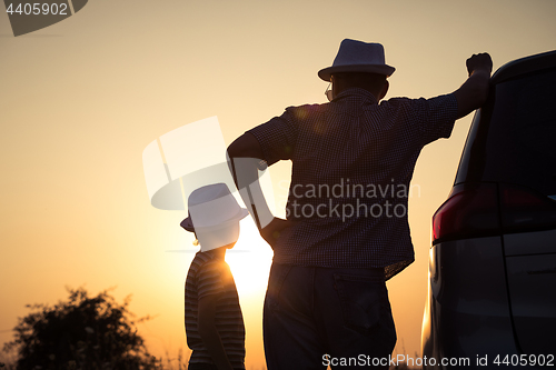 Image of Father and son playing in the park at the sunset time.