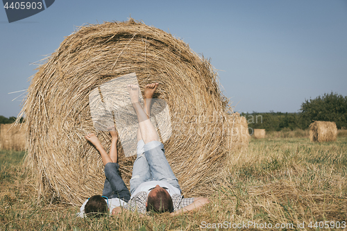 Image of Father and son lying in the park at the day time.