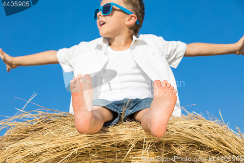 Image of Happy little boy playing in the park at the day time.