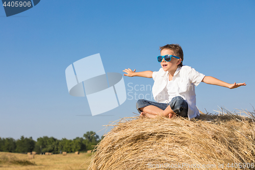 Image of Happy little boy playing in the park at the day time.