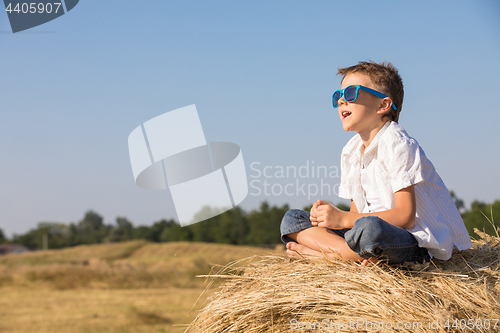 Image of Happy little boy playing in the park at the day time.