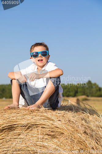 Image of Happy little boy playing in the park at the day time.