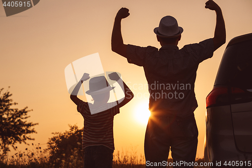 Image of Father and son playing in the park at the sunset time.