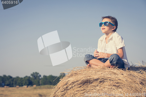 Image of Happy little boy playing in the park at the day time.