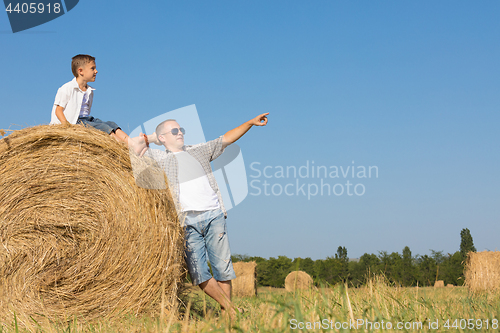 Image of Father and children standing in the park at the day time.