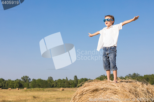 Image of Happy little boy playing in the park at the day time.