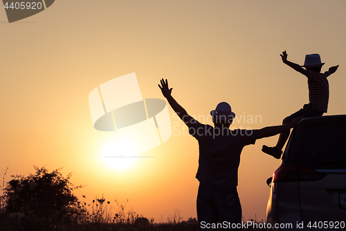 Image of Father and son playing in the park at the sunset time.