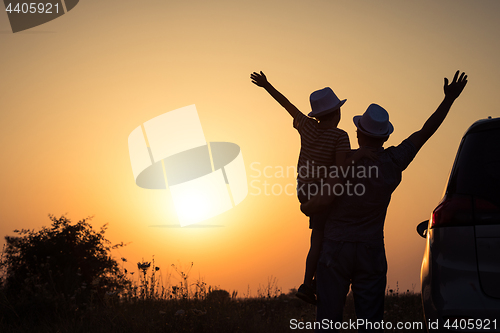 Image of Father and son playing in the park at the sunset time.