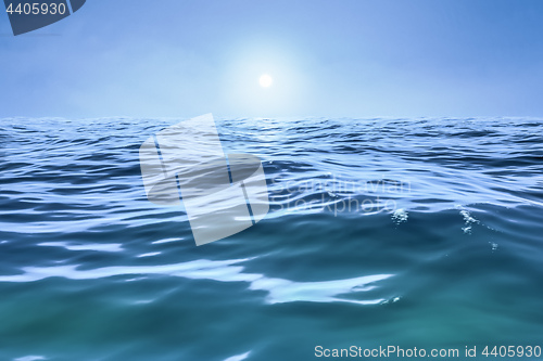 Image of a blue ocean with sun over the horizon