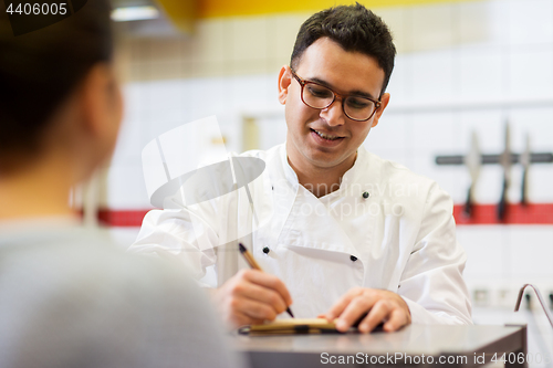 Image of chef at fast food restaurant writing order