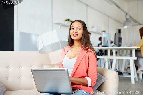 Image of happy woman with laptop working at office