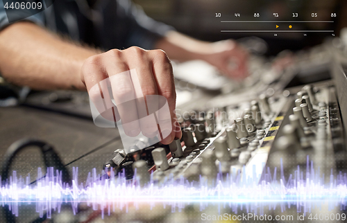 Image of hands on mixing console in music recording studio