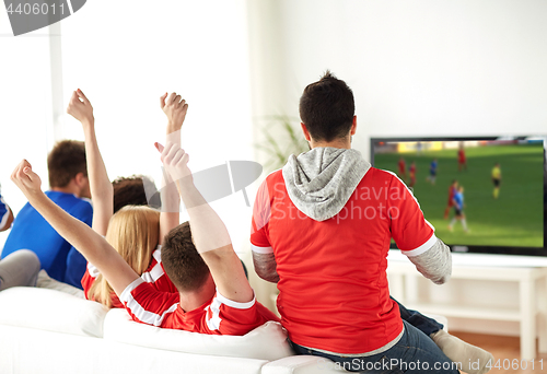 Image of friends or soccer fans watching game on tv at home