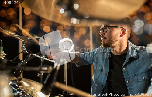 Image of male musician playing drums and cymbals at concert