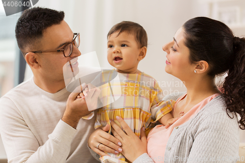 Image of happy family with baby daughter at home