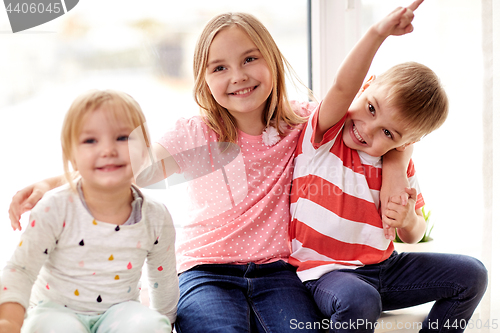 Image of happy little kids hugging at window