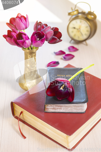 Image of Holy Bible and old gold alarm clock on wood table