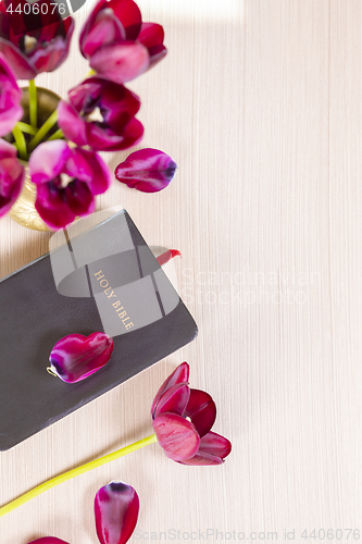 Image of Holy Bible and flowers on wood table