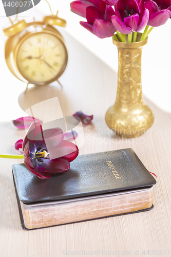 Image of Holy Bible with flowers on wooden table