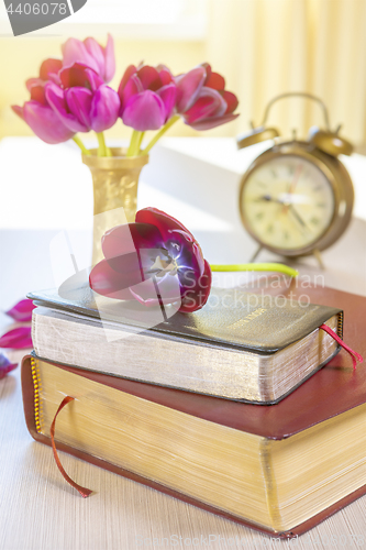 Image of Holy Bible and old gold alarm clock on wood table