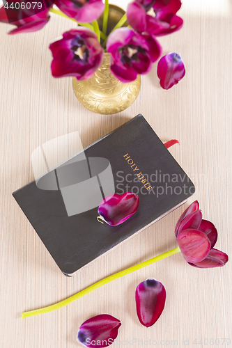 Image of Holy Bible with flowers on wooden table