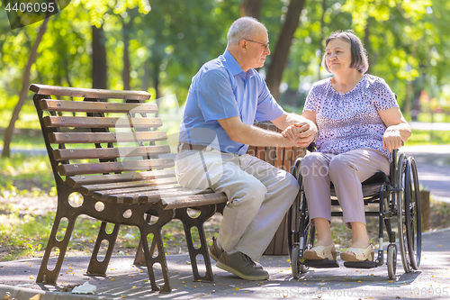 Image of Elderly man strengthens his wife in the wheelchair 