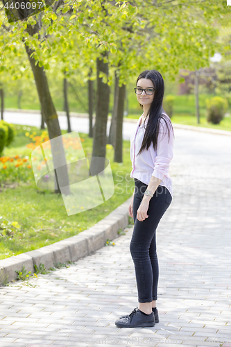 Image of Teenager brunette girl walking in park