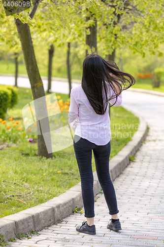 Image of Teenager brunette girl walking in park