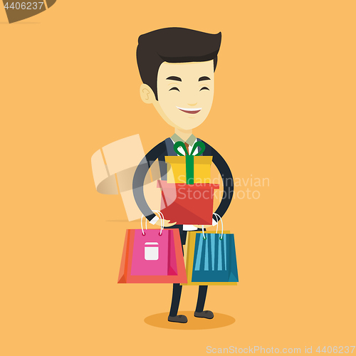 Image of Happy man holding shopping bags and gift boxes.