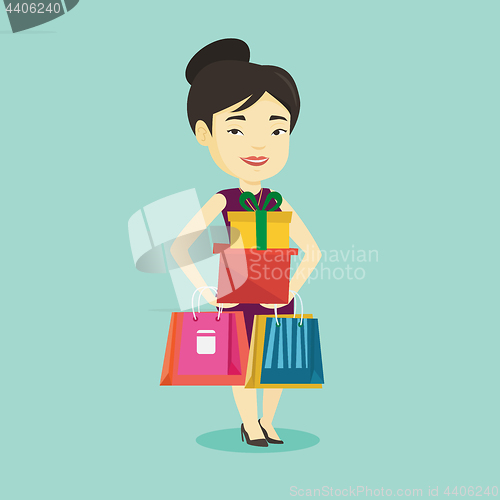 Image of Happy woman holding shopping bags and gift boxes.