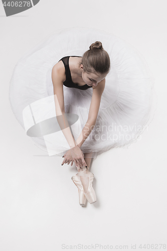 Image of Ballerina dancer sitting down with her legs crossed