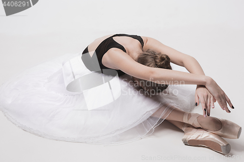 Image of Ballerina dancer sitting down with her legs crossed