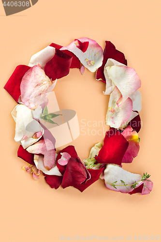 Image of Letter Q made from red roses and petals isolated on a white background