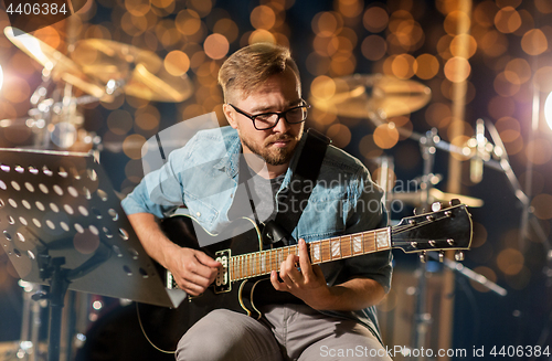 Image of man playing guitar at studio rehearsal