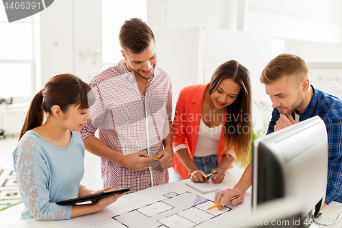 Image of creative team with blueprint working at office